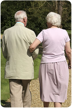 An eldery couple walking arm in arm